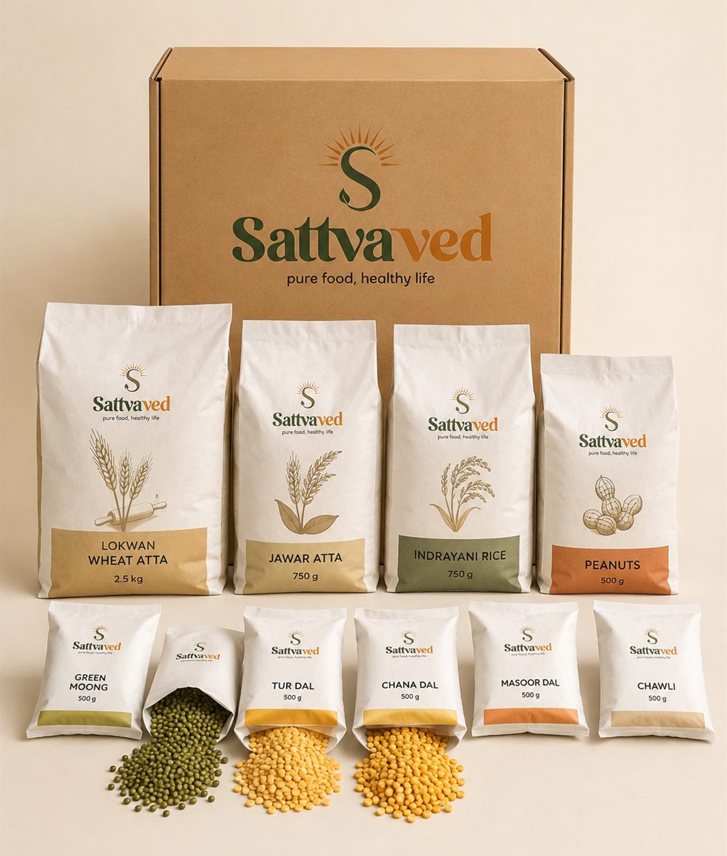 Sattvaved weekly kit — kraft delivery box behind labelled packets of wheat atta, jawar atta, rice and peanuts, with open dal sachets in front